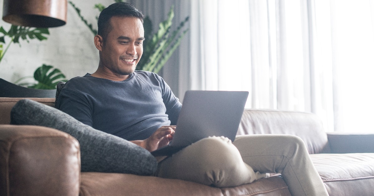 Asian man looking at the computer at home