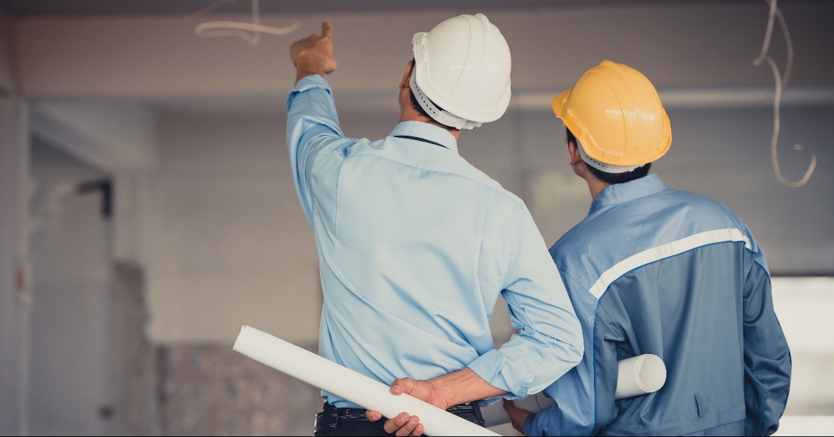 engineer team with hard hat and blueprint talking together