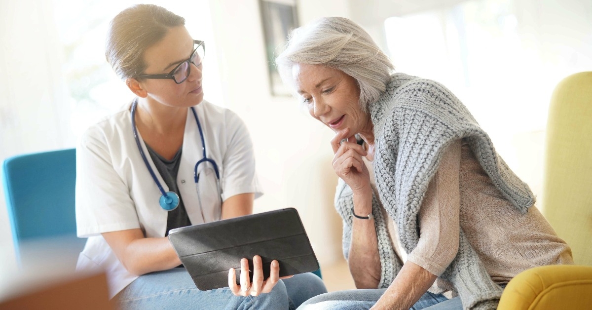 doctor going through results and medication on tablet with senior patient