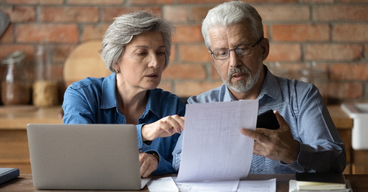 serious mature couple checking financial documents
