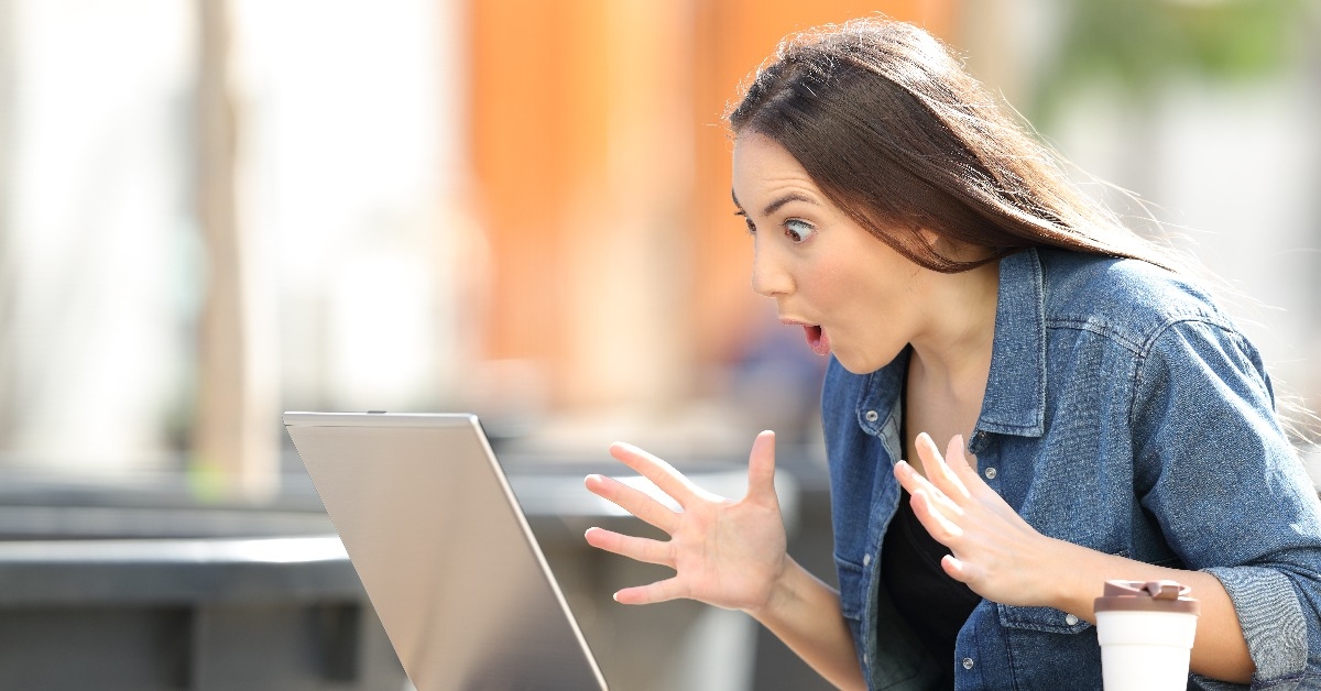 Amazed woman finding online content on laptop in a park