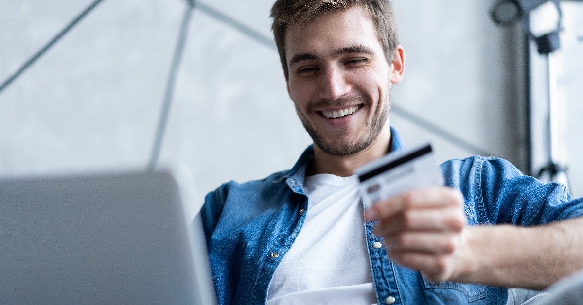 man with laptop computer and credit card at home