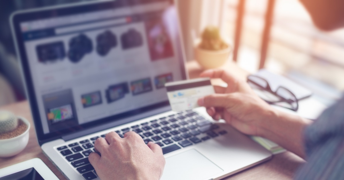 Man's hand using laptop computer for online shopping with credit card
