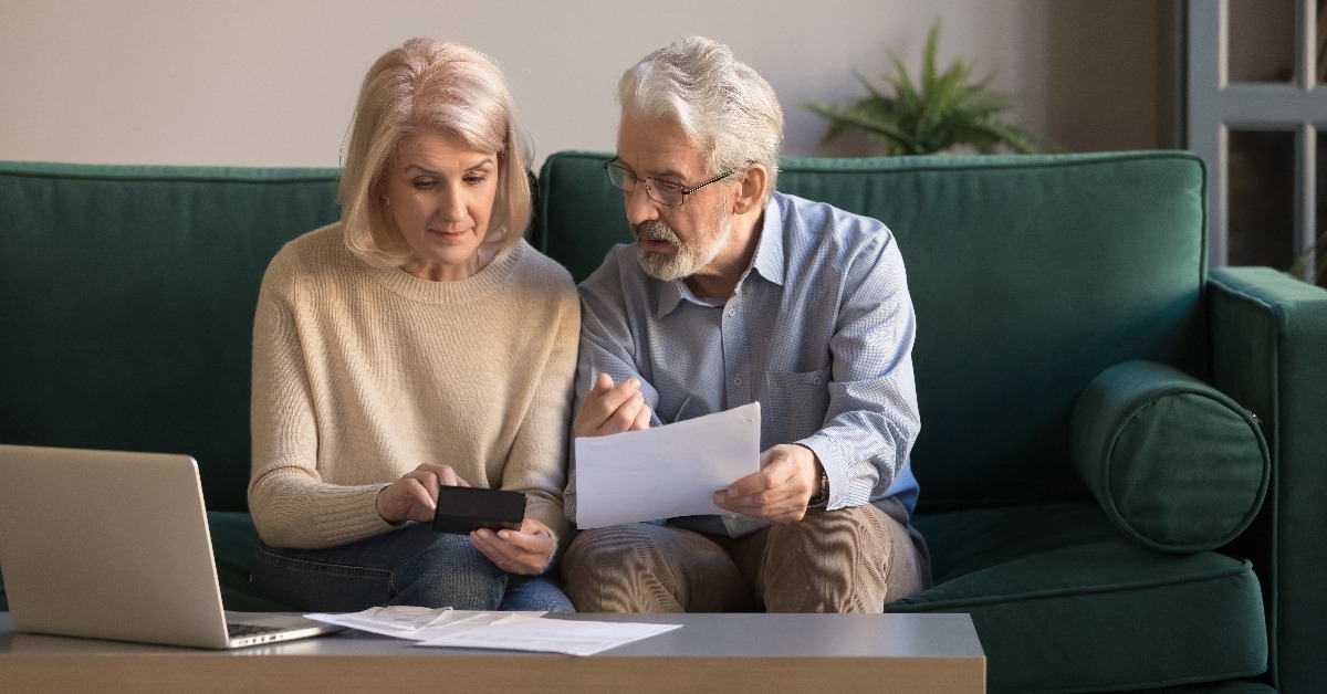 Serious mature couple calculating bills