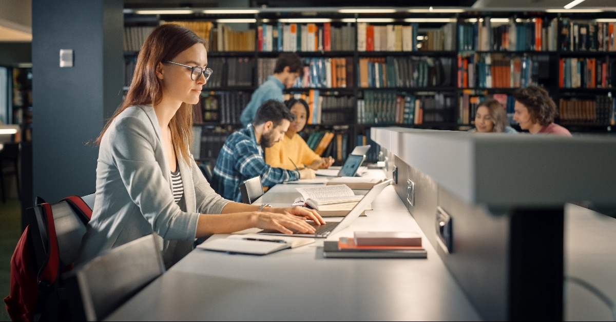 college student using a laptop in a library