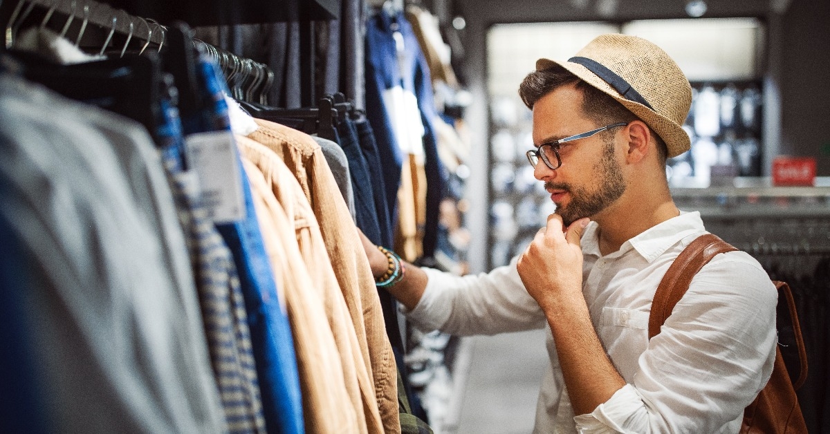 Handsome man shopping for new clothes in store