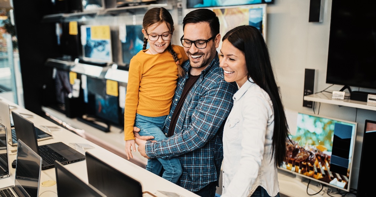 Happy family buying laptop in store