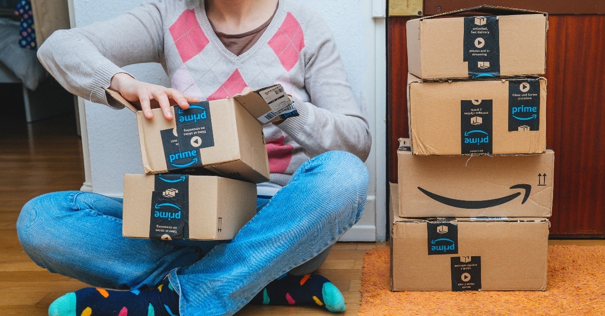 Woman next to stack of Amazon Prime packages