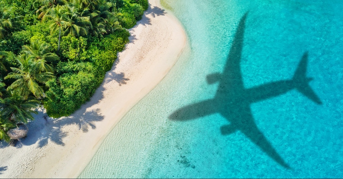 Travel concept with airplane shadow and beach