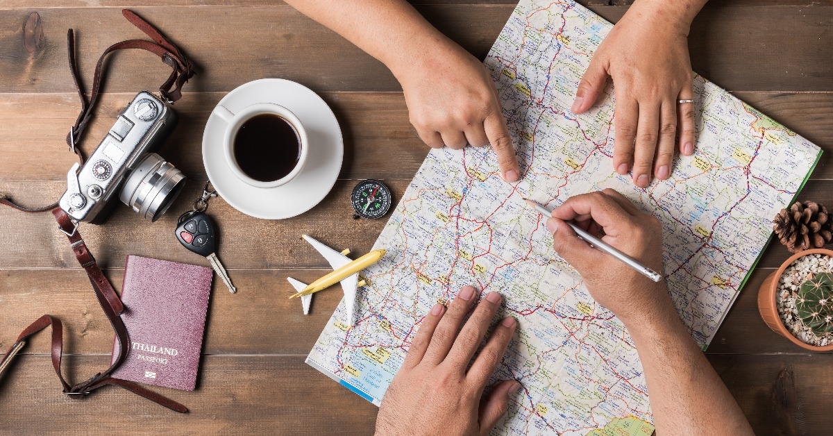 Young couple planning vacation trip with map