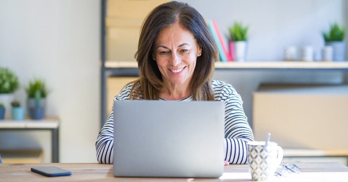  senior woman sitting at the table at home working using computer laptop 