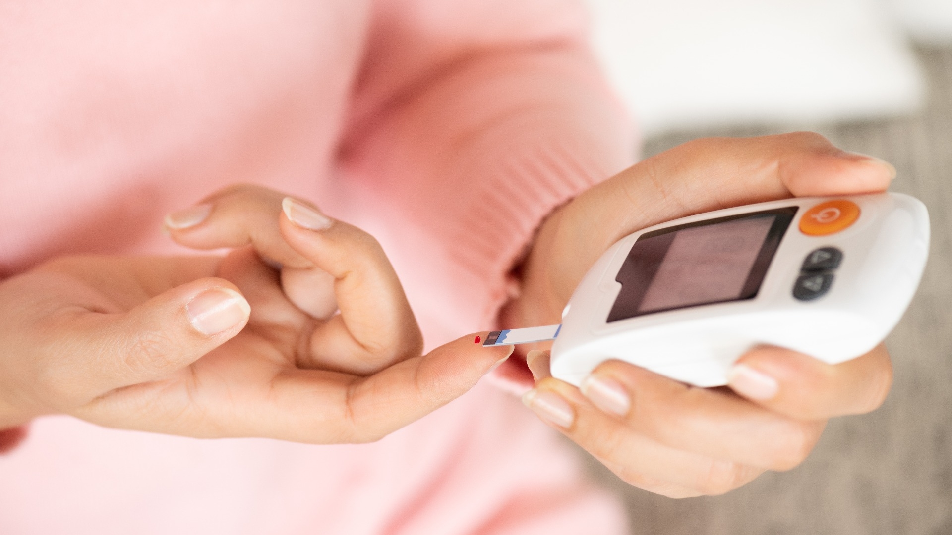 woman hands checking blood sugar level by glucose meter