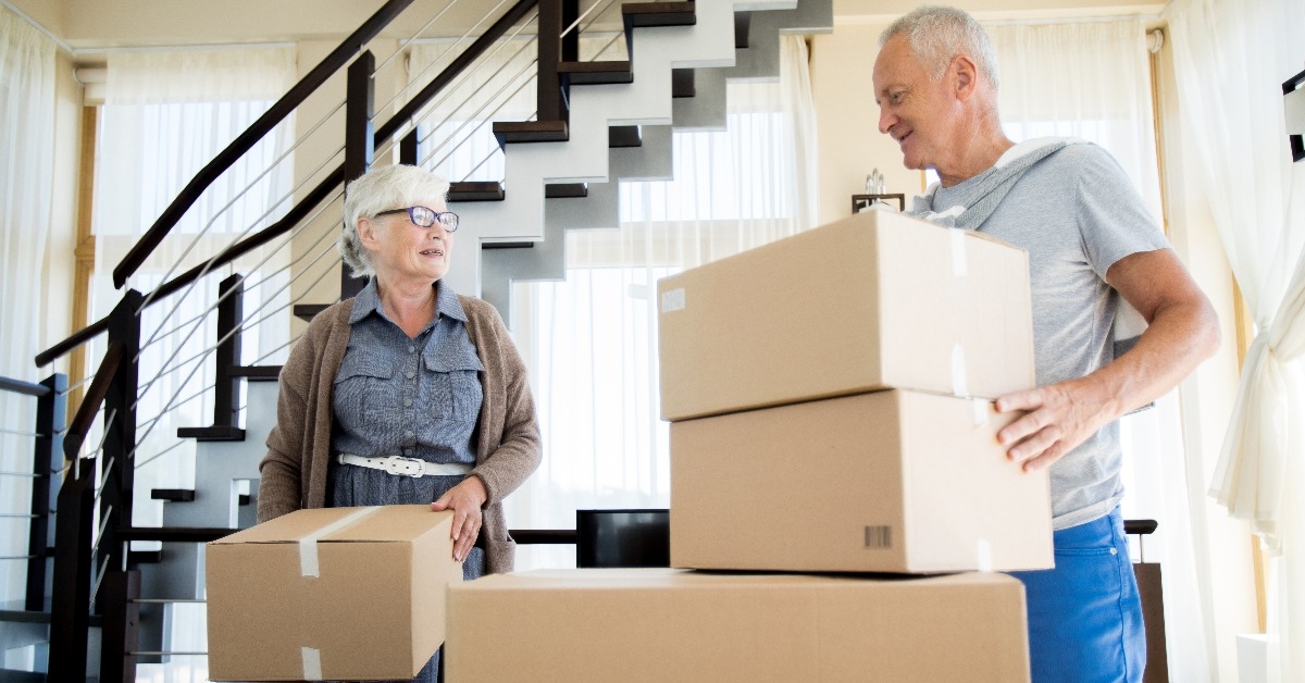  happy senior couple packing cardboard boxes
