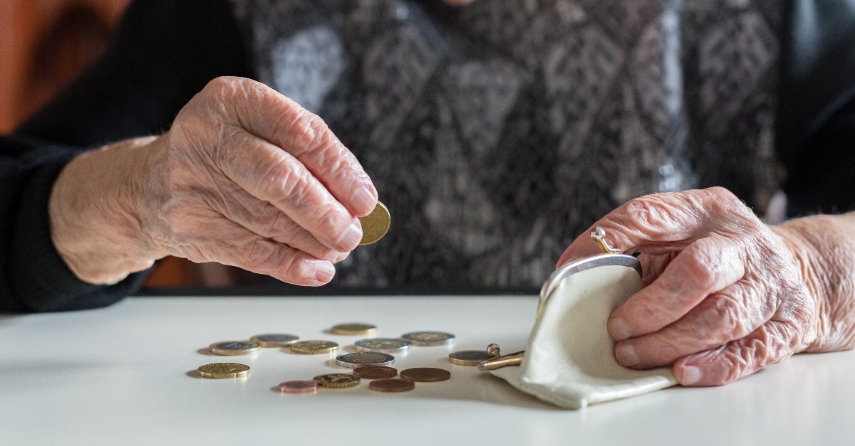 old woman counting remaining coins from the pension in her wallet