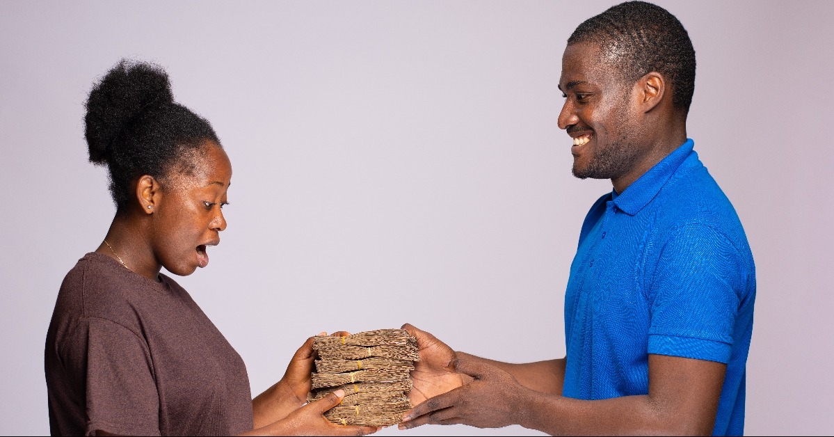young african woman receiving money from a business agent