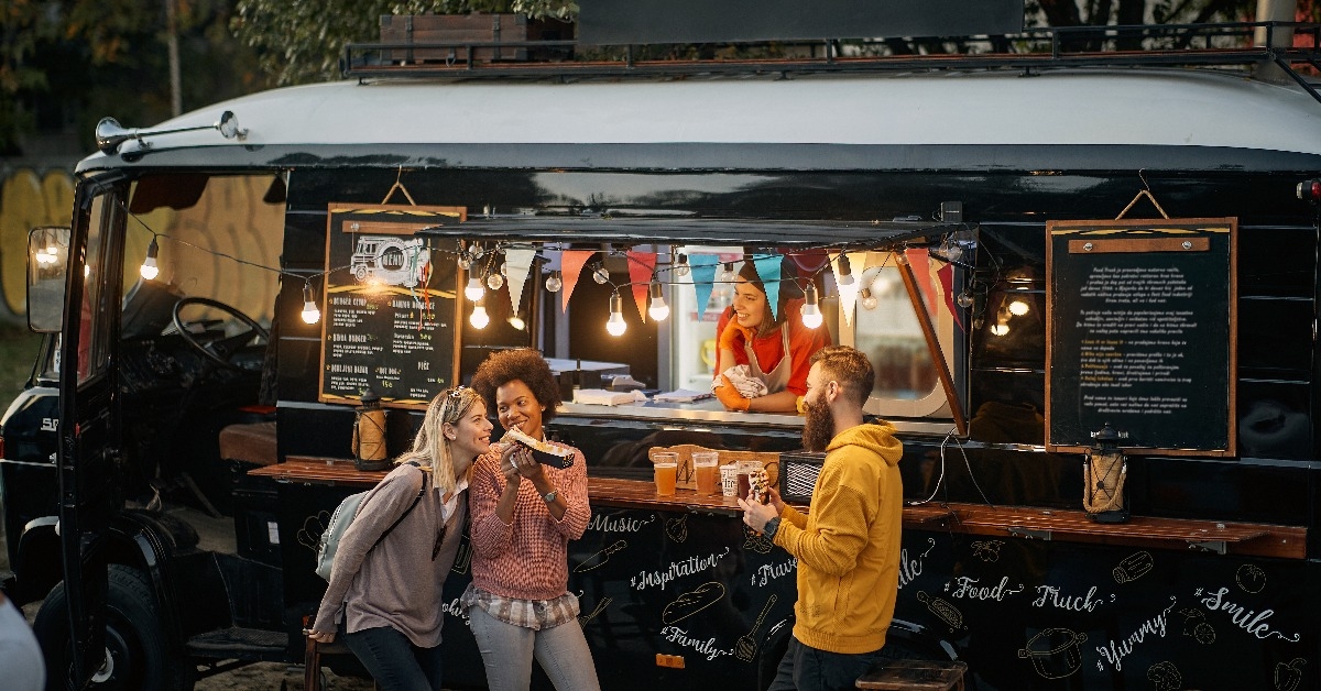 multiethnic group of people socializing while eating outdoor