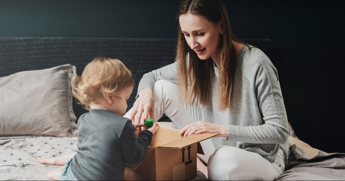 mother and child playing with big cardboard box