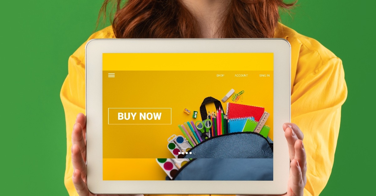 young student showing tablet computer with school stationery shop on screen