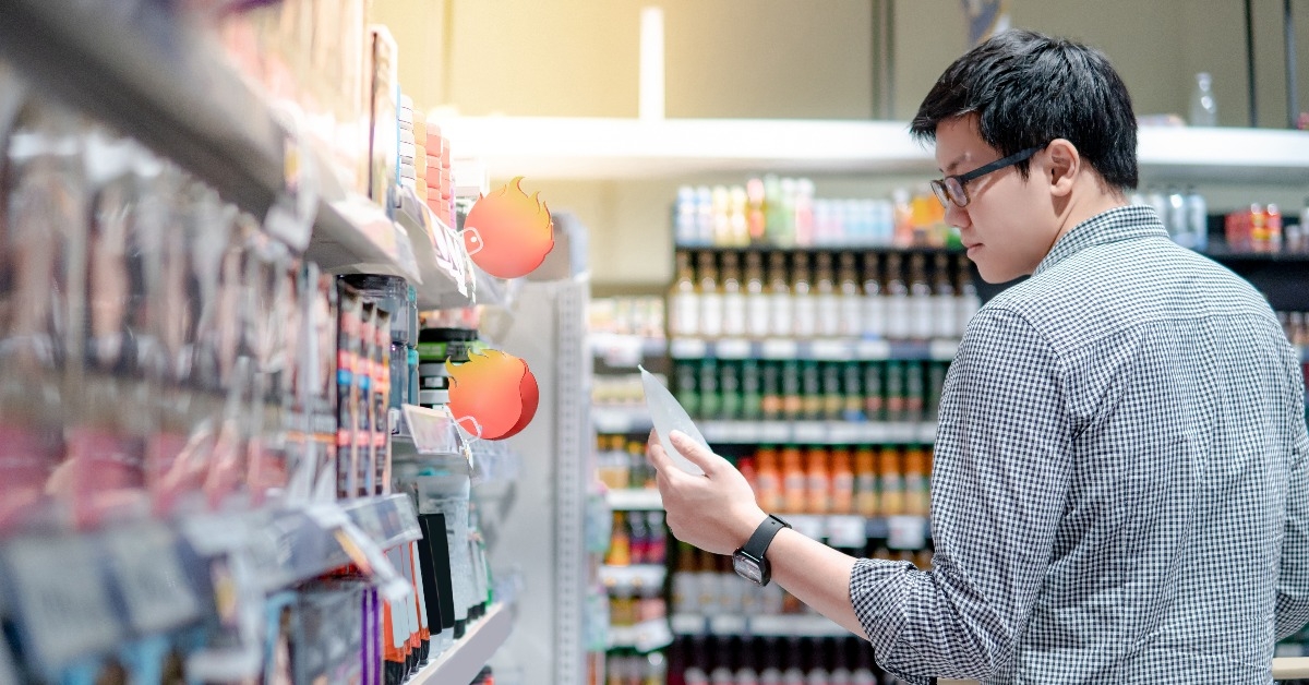 Asian man shopper choosing hair gel for men from shelf in supermarket