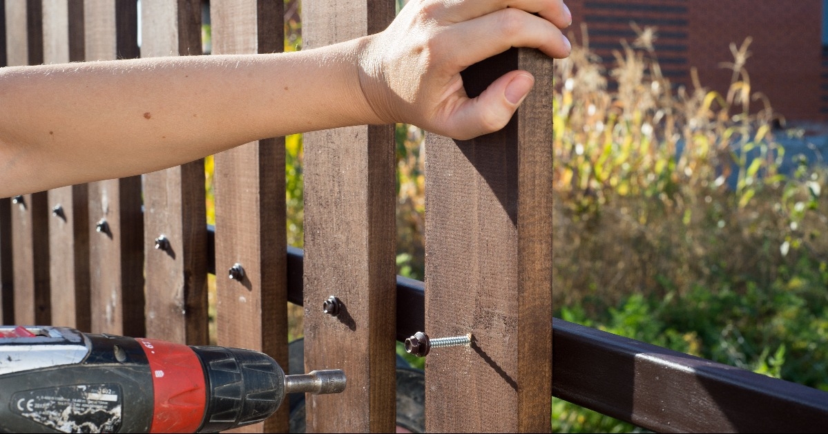  hand screwing wood plank to metal construction