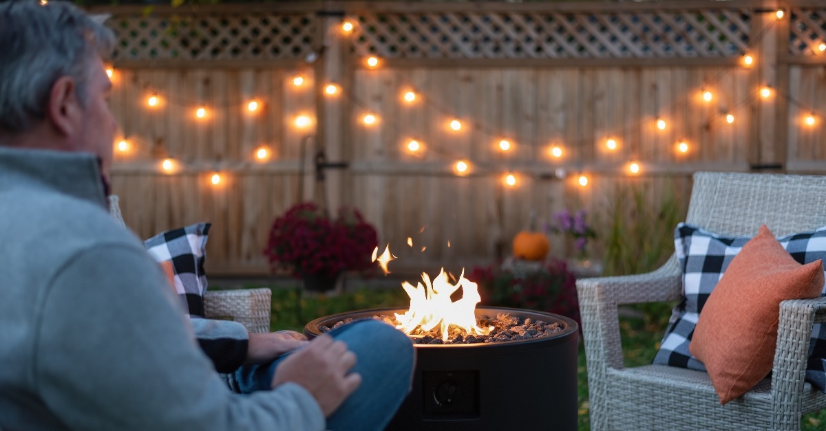 Man relaxing in the backyard by a fire