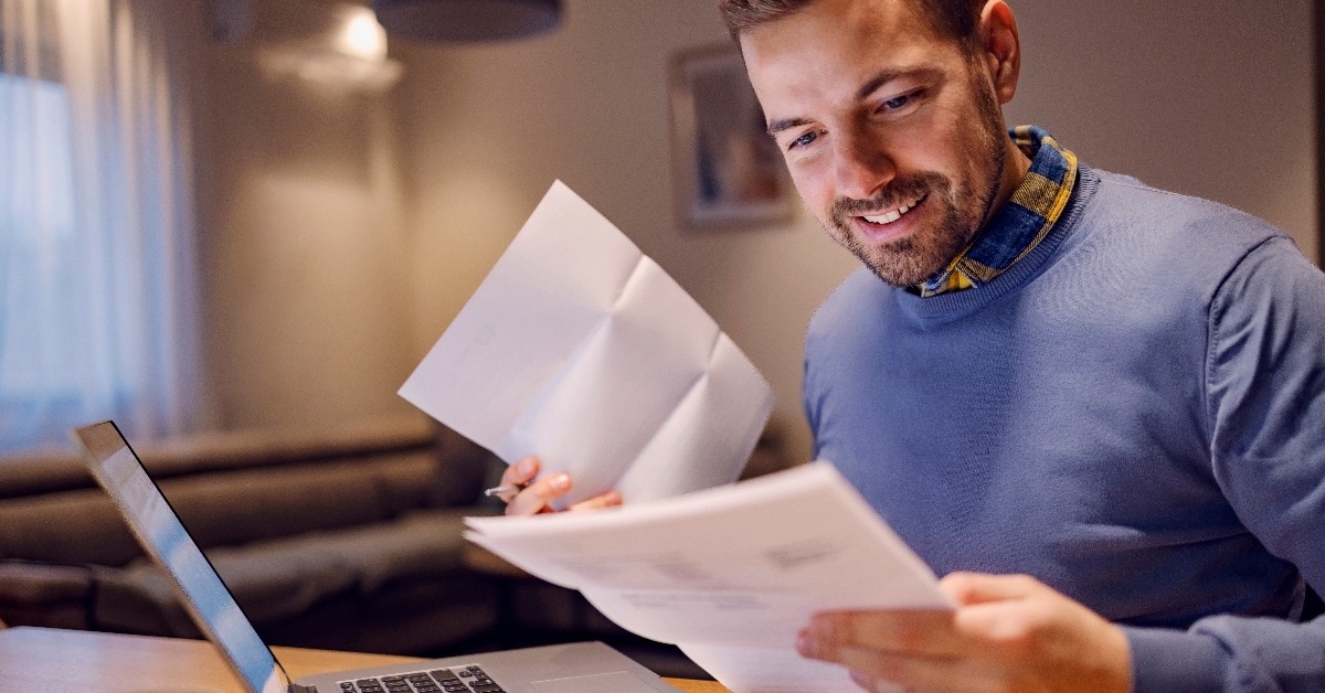  smiling man holding bills in his hands 