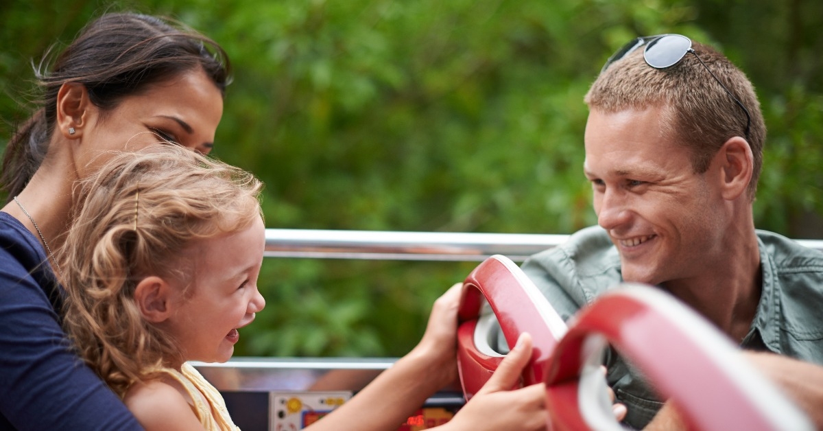a happy young family sitting on a bus