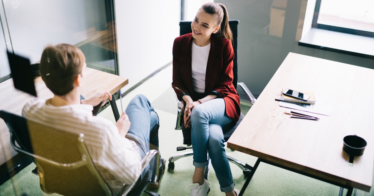 cheerful office workers talking behind glass door
