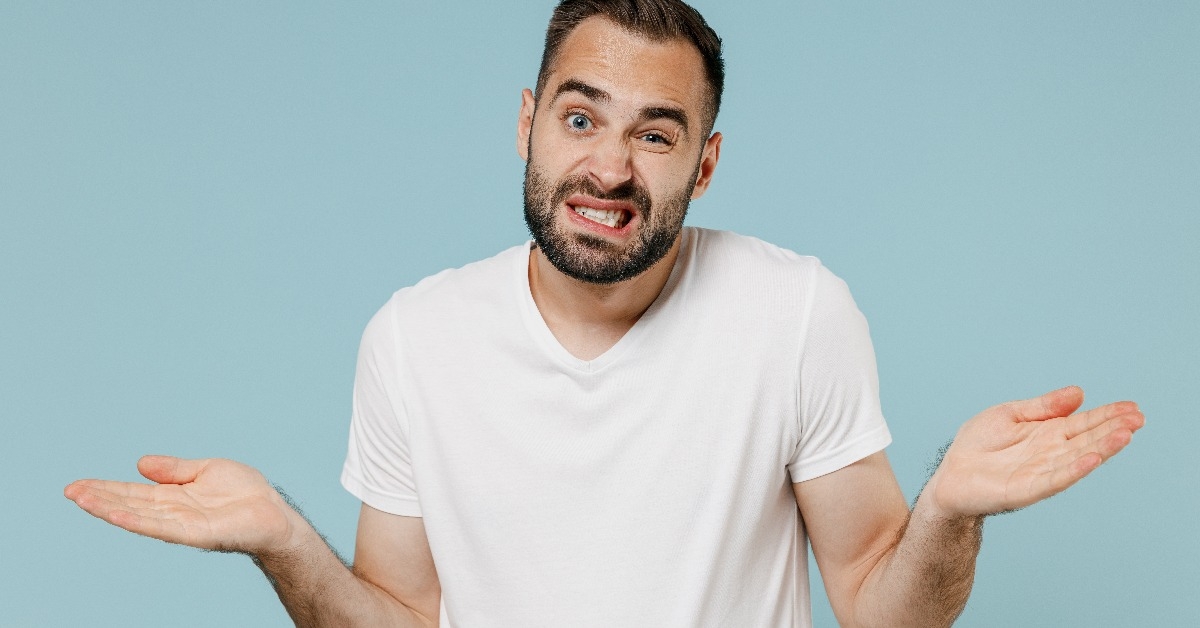white t-shirt hrugging shoulders looking puzzled