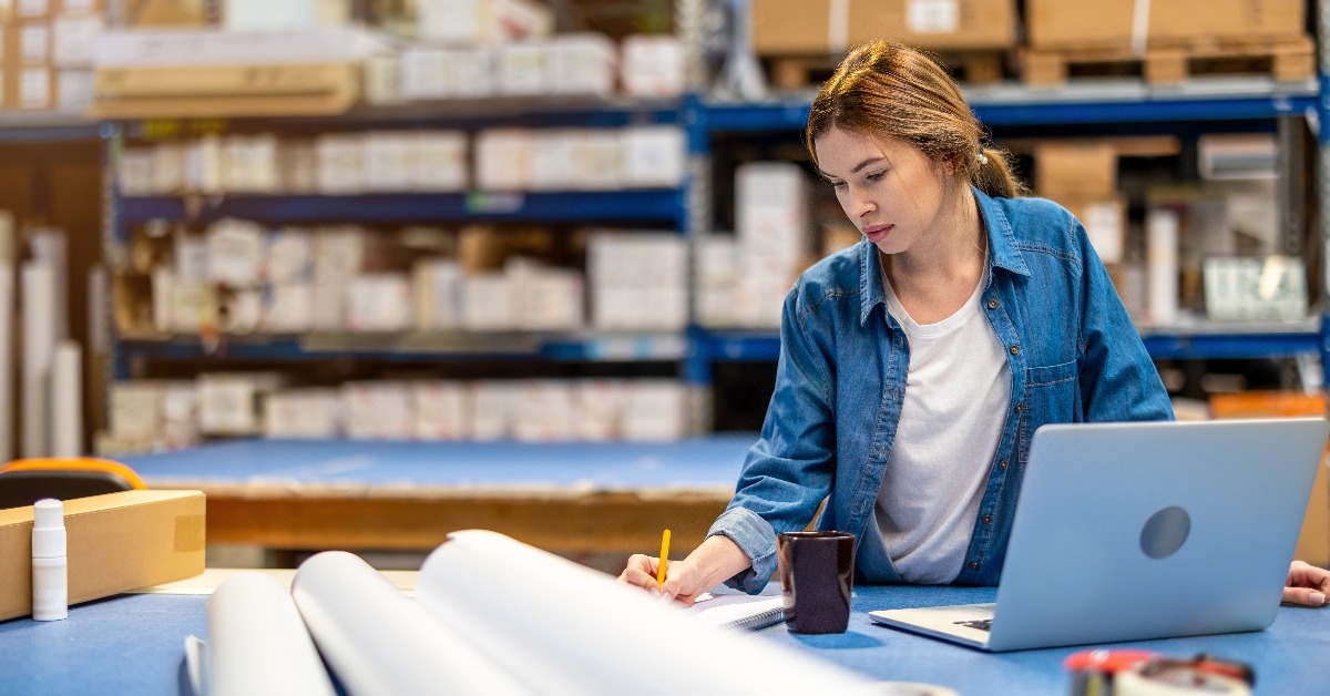 woman using laptop at warehouse