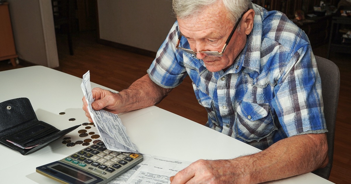 senior man sitting at the table and calculating finances