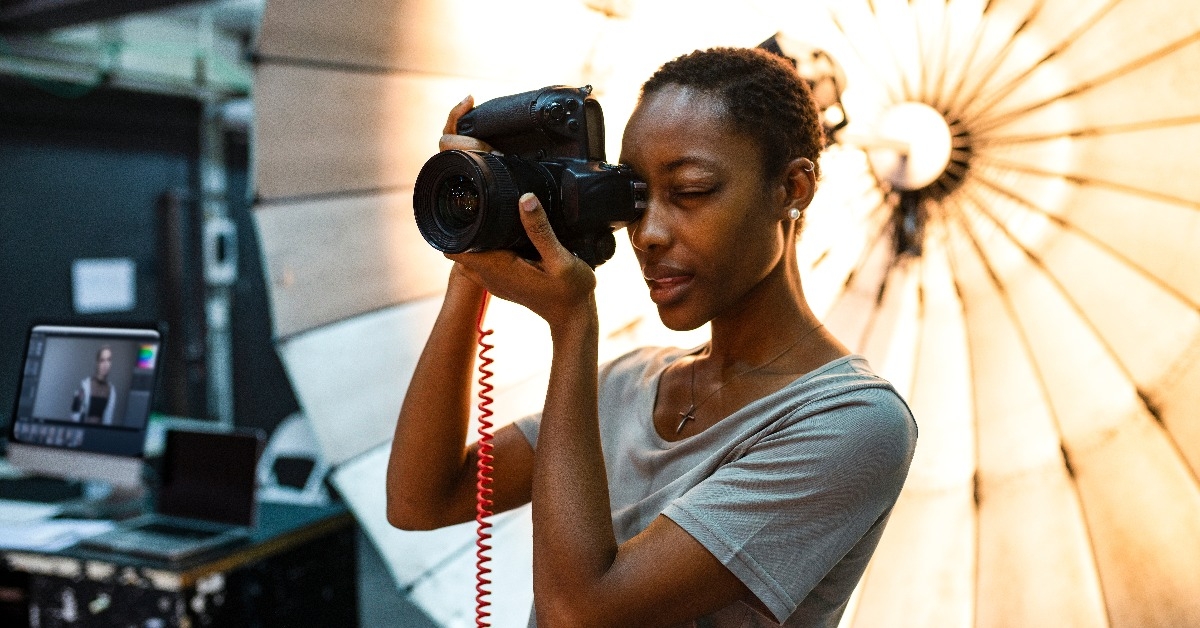 young photographer standing in front of a reflective umbrella 