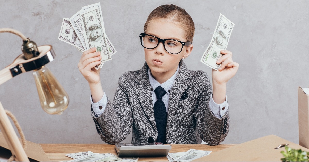 pensive child holding money in hands