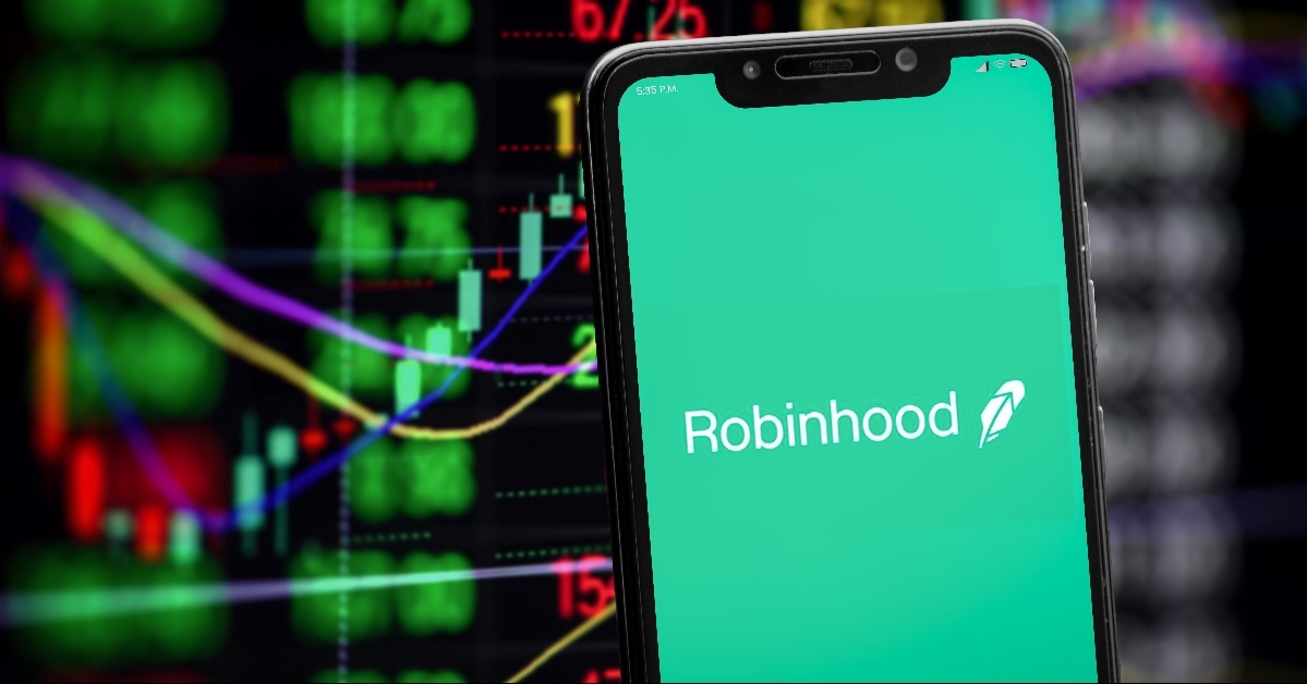Robinhood logo on the smartphone screen and stock market chart on the background