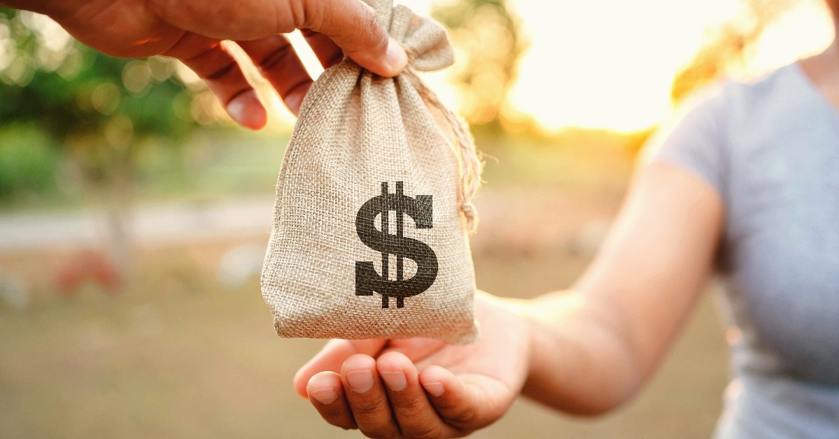 hand giving money bag for woman