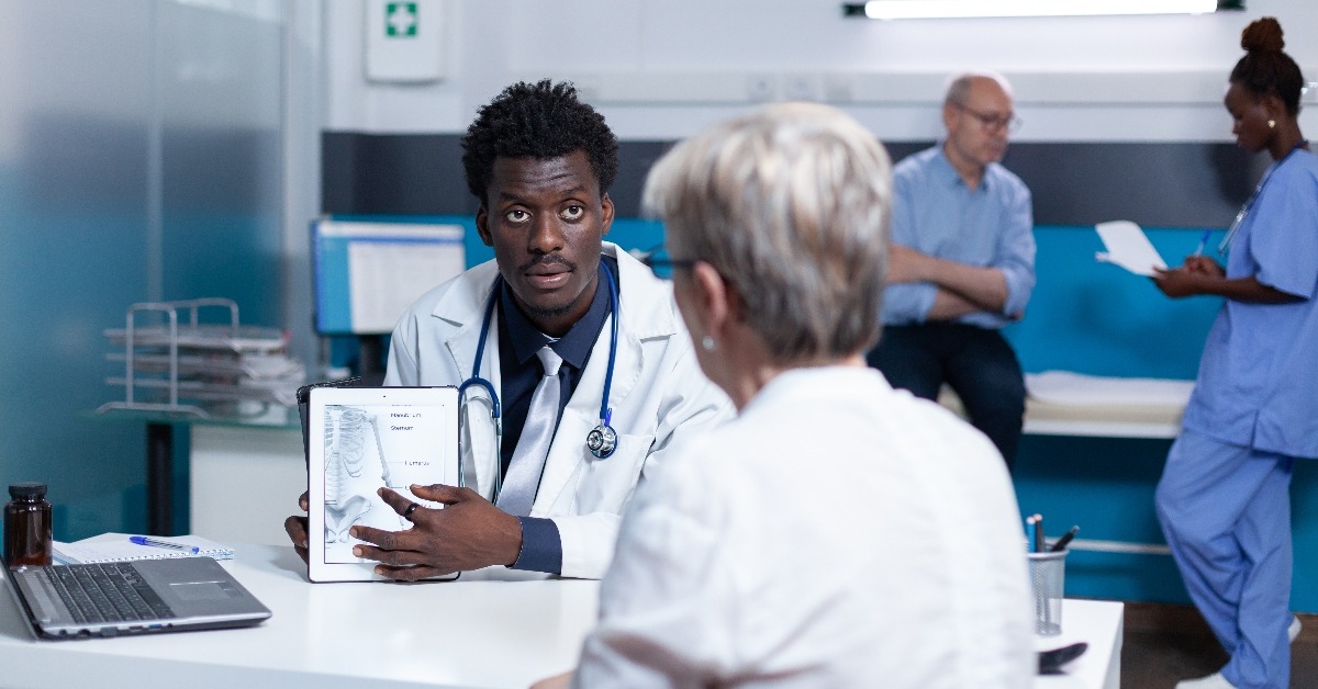 clinic specialist talking with retired woman about health risks 
