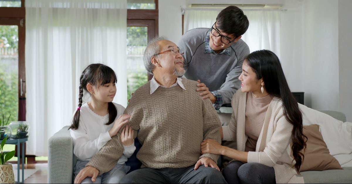 grandpa sitting at sofa couch with his family 