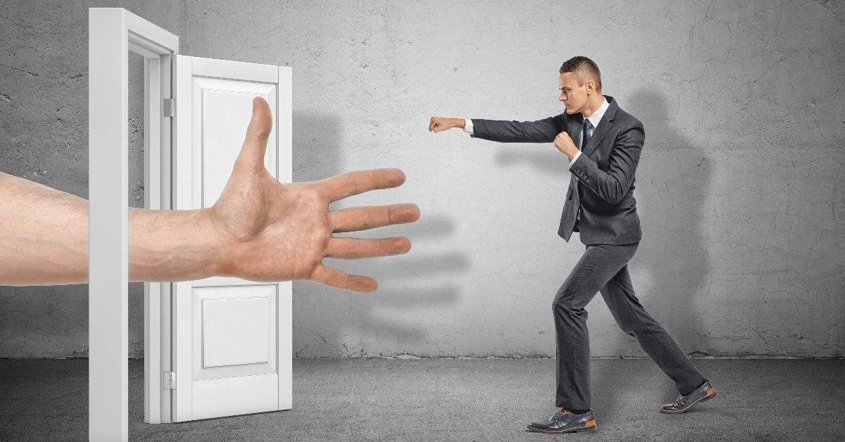  male open hand appearing through white doorway and businessman making kicking gesture