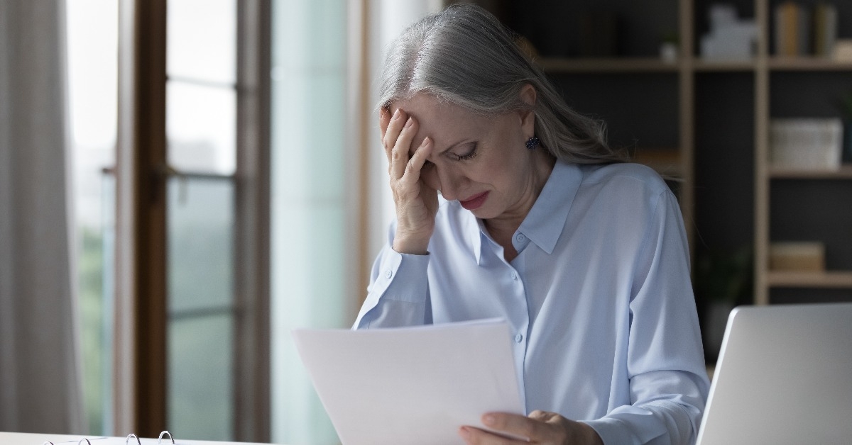 senior woman reading paper documents at workplace