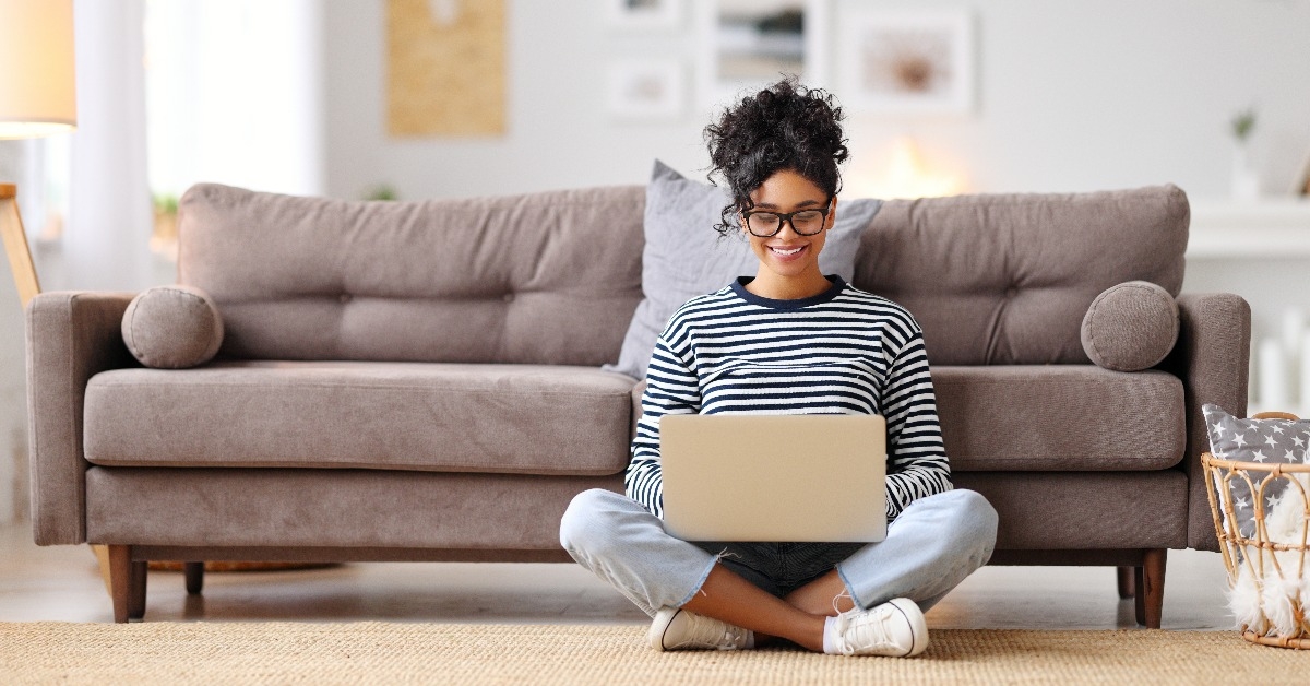 relaxed ethnic woman using laptop with interest at home 