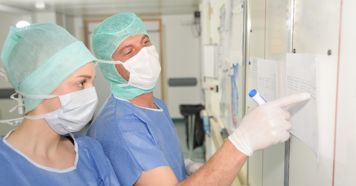 surgeons looking at schedule on board