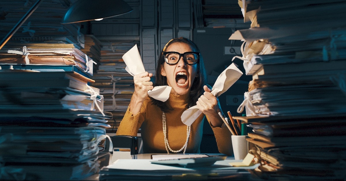 angry stressed office worker overloaded with paperwork