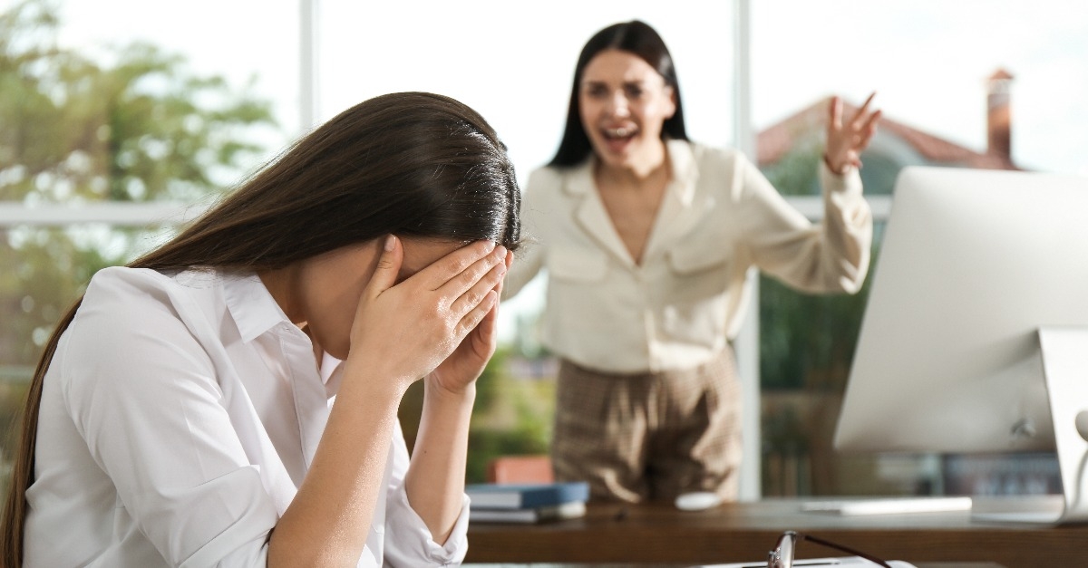 boss screaming at employee in office
