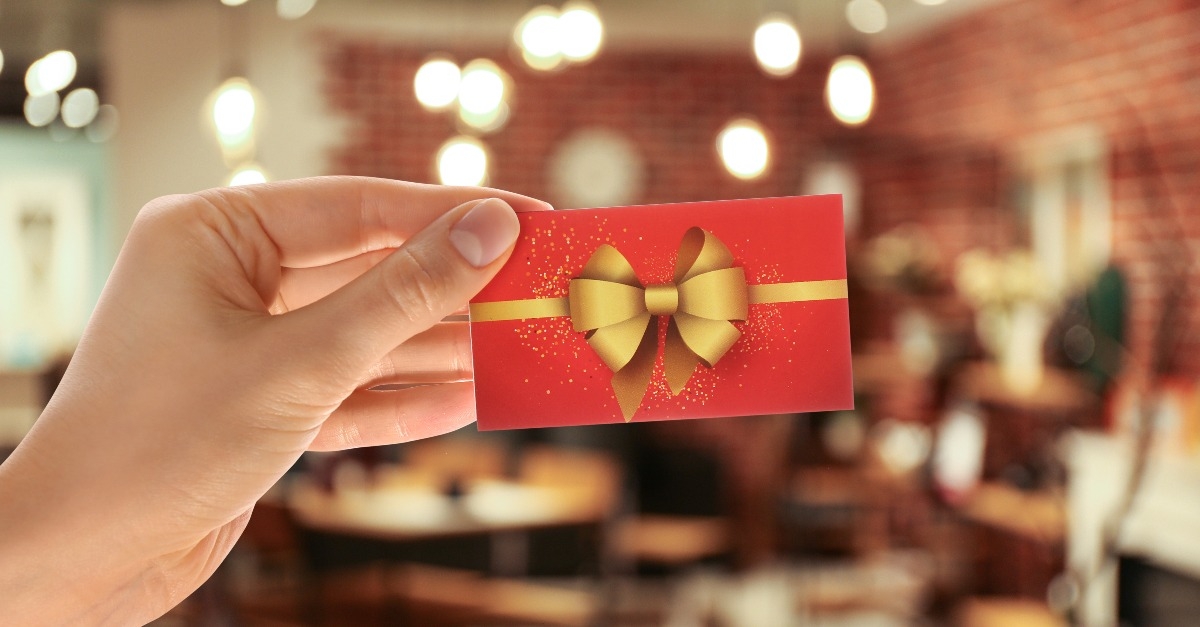 woman holding gift card in restaurant