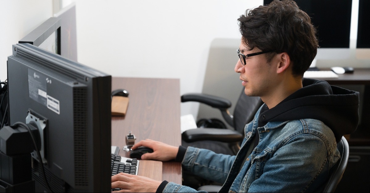young man using a computer with dual monitor
