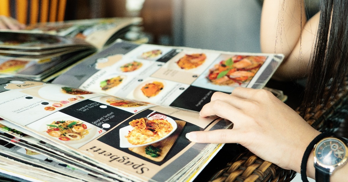 young women looking menu at restaurant