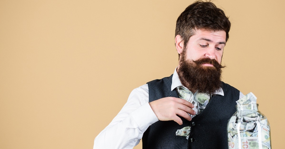 bearded guy hold jar full of cash savings