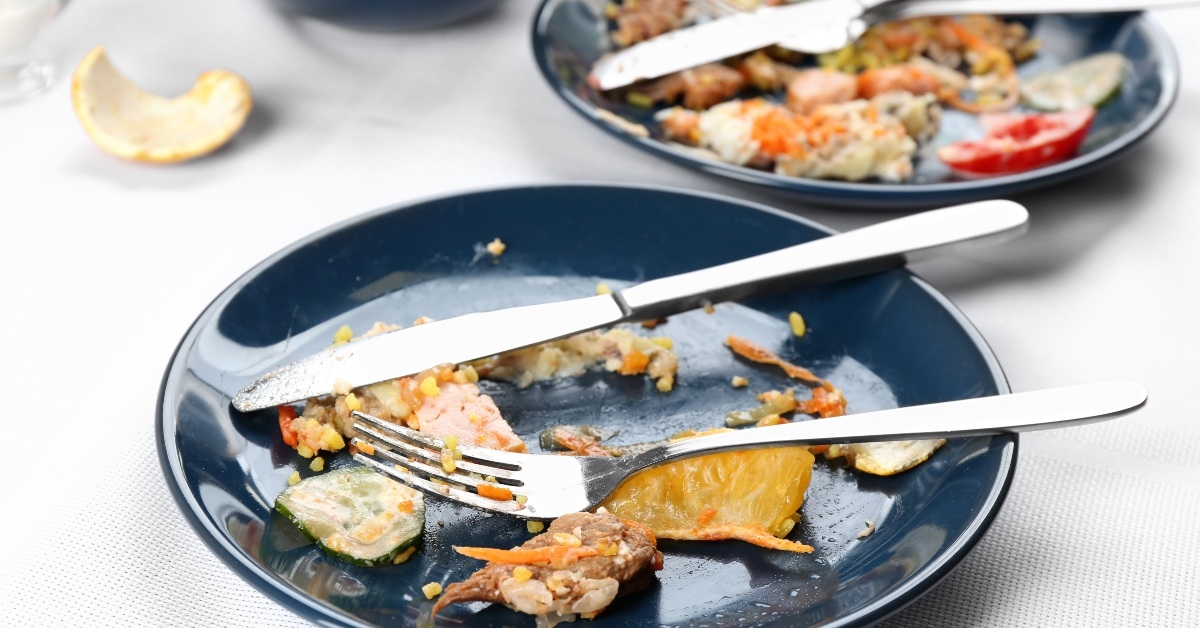 Plate with leftover food fork and knife on top
