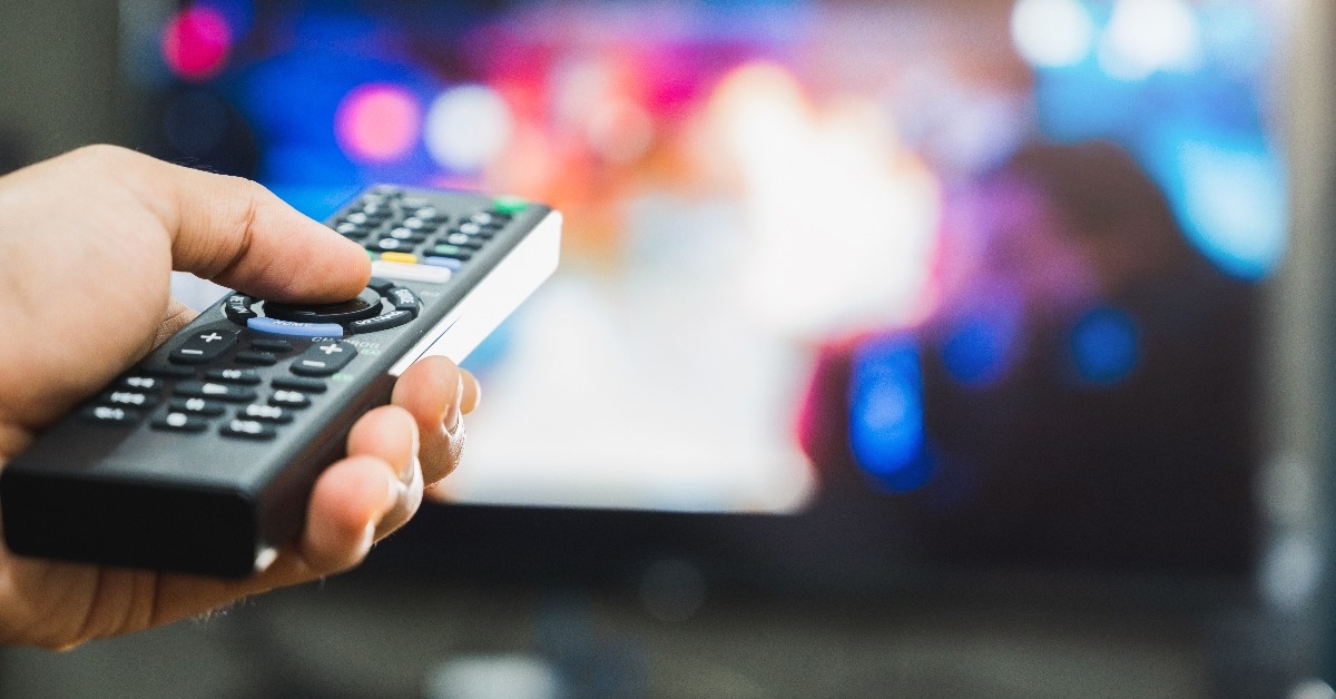 holding television remote control