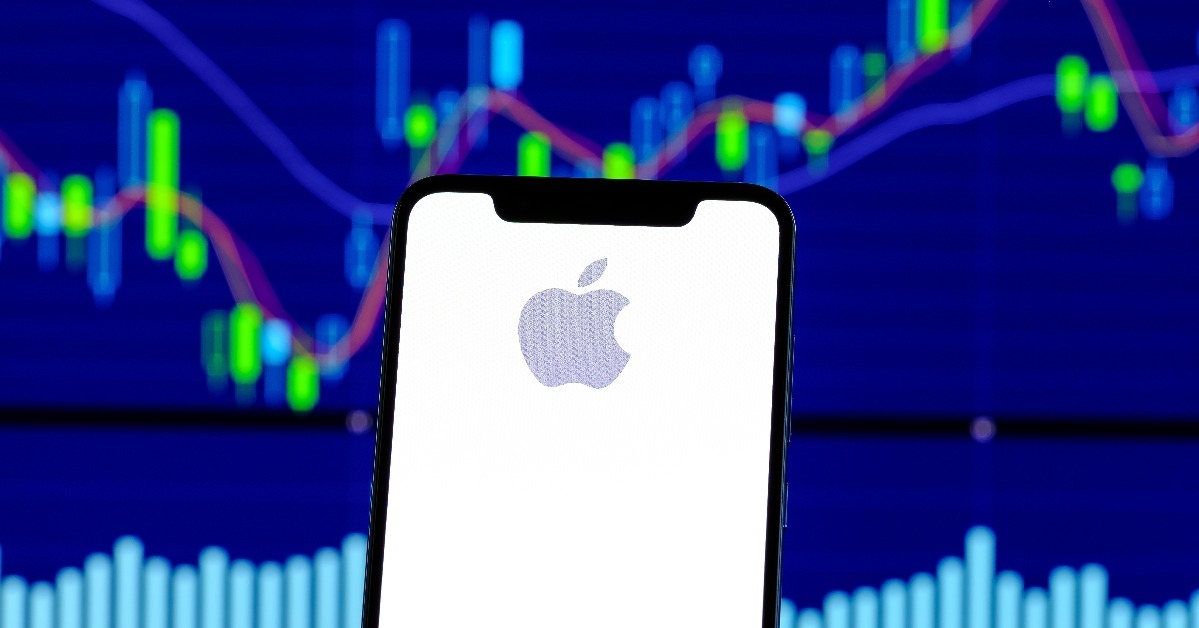Apple logo is seen on an smartphone over stock chart